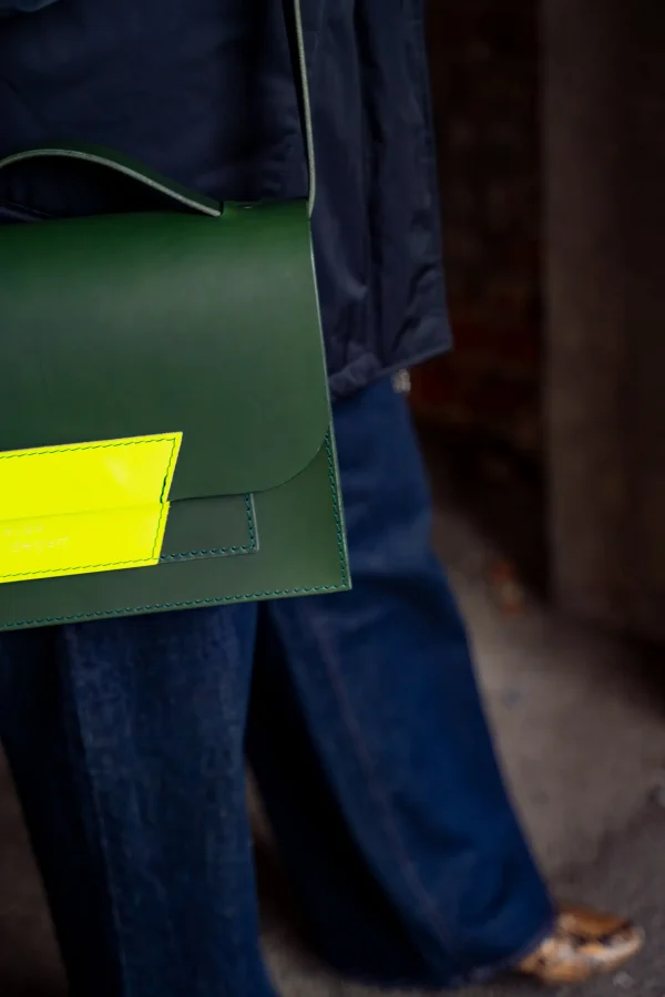 Detail van de groene Sofie L. met fluogeel contrast aan de schouder van een model.