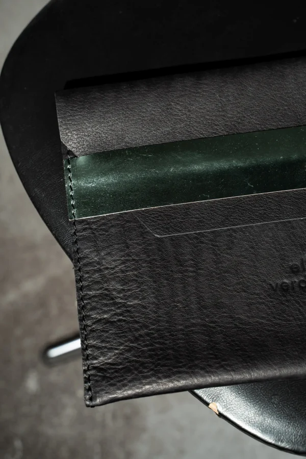 Detail van de Kate W. tablethoes in zwart leder met groen métallic sluitriem.